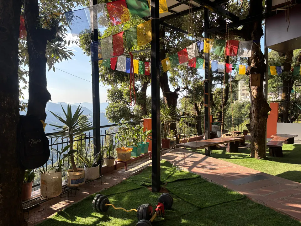 Sunny terrace with a wooden swing, prayer flags and mountain views